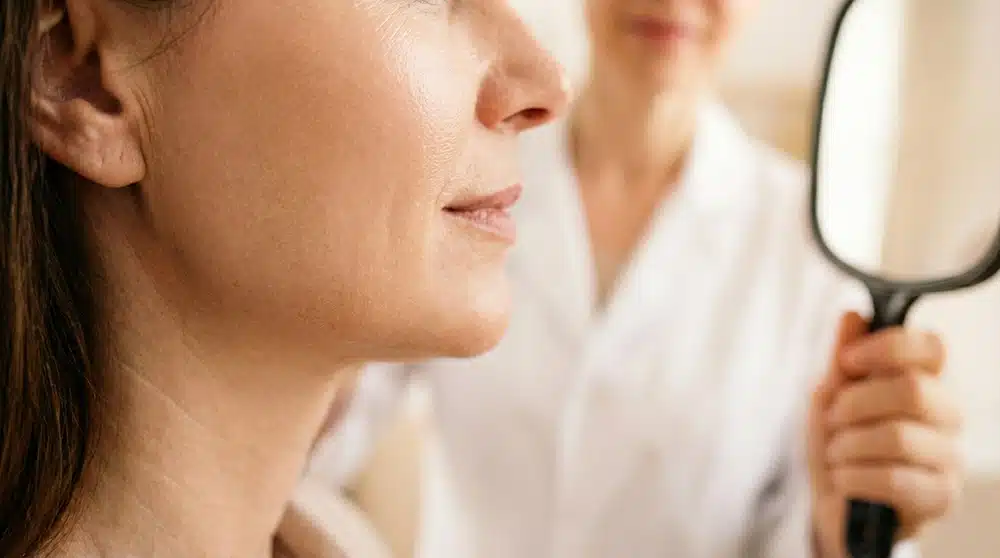 Médico estético evaluando armonización facial y rinomodelación de una paciente en Novo Clinique Granada